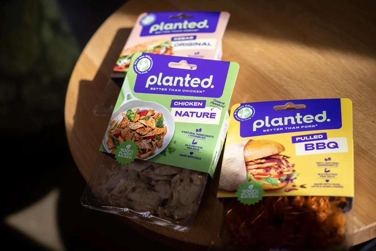 Auf einem Tisch liegen drei Packungen planted Essen.